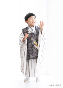 七五三３歳：白いストライプ柄にグレーの被布を合わせた着物を着た3才の男の子。