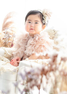 ベビー・バースデー：フリフリのかわいいレースの衣装を着た1歳の女の子のお誕生日フォト。