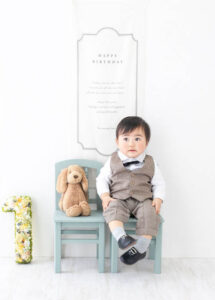 ベビーバースデー：シャツに蝶ネクタイ、ベストとフォーマルな姿で1歳を祝う男の子の赤ちゃん