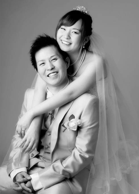 ウェディング：ドレスとタキシードを着た夫婦が仲良く寄り添う様子