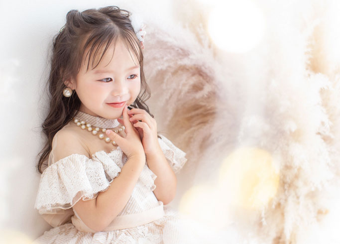 七五三：くすみピンクのオフショルダードレスに身を包んだ七五三3才の女の子。