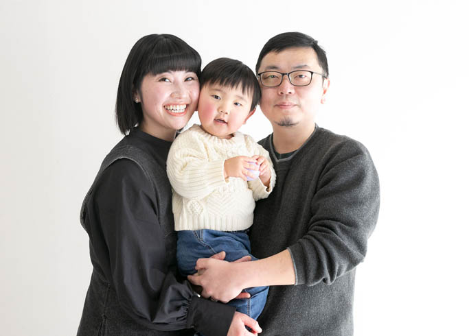 ファミリーフォト：小さな男の子を真ん中にだっこしたパパママお揃いコーデの家族写真。