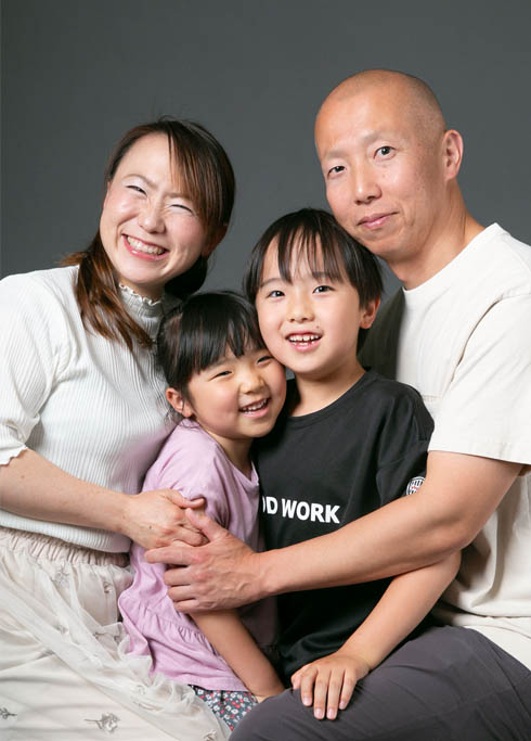 ファミリー：娘と息子をハグする夫婦の家族写真