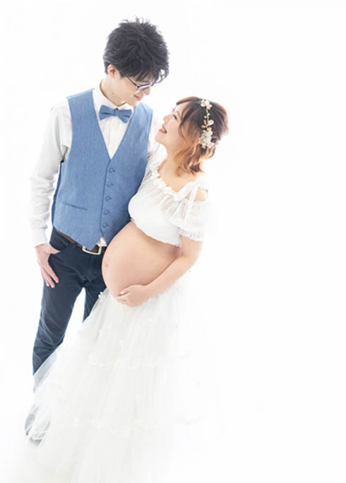マタニティ：もうすぐ赤ちゃんが生まれる大きなお腹の妻と夫が見つめあうマタニティフォト。