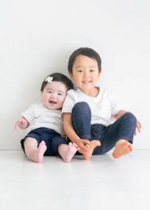 ベビー・バースデー：小さな赤ちゃんの妹とお兄ちゃんのお揃いコーデ兄妹ショット。