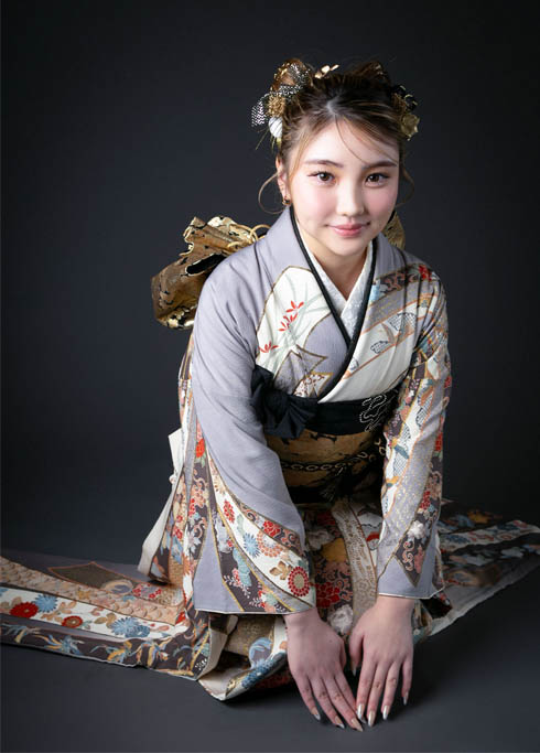 成人：正座をして手をつく、グレーの振袖を着た二十歳の女性