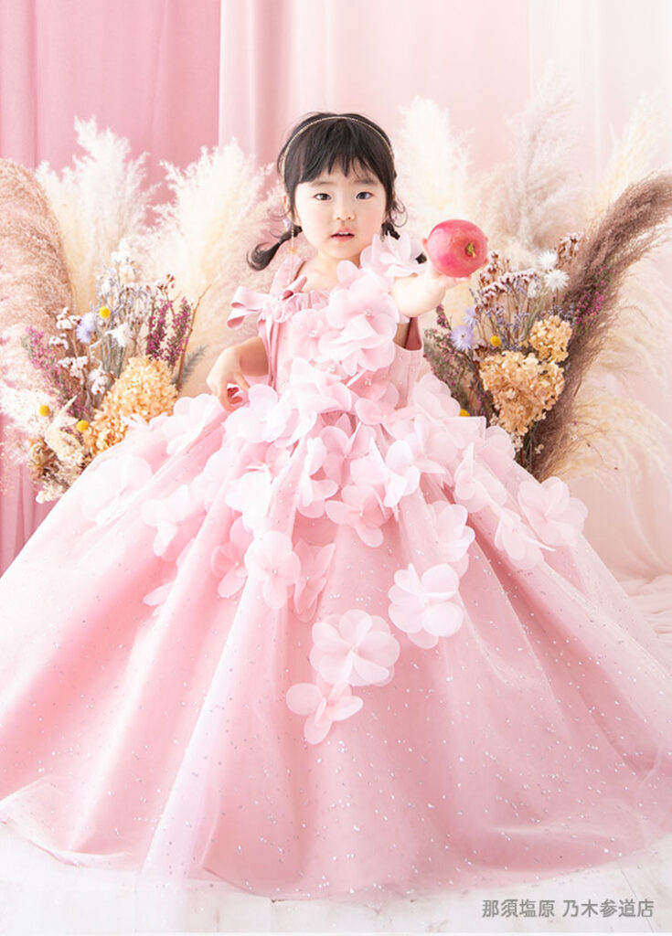 七五三３歳：ピンクのたくさんの花が散らされたドレスを着た3才の女の子。