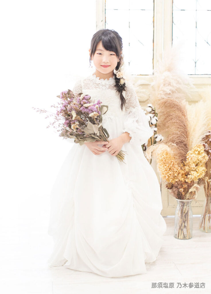 七五三７歳ドレス：白いレース袖のドレスを着た7才の女の子。