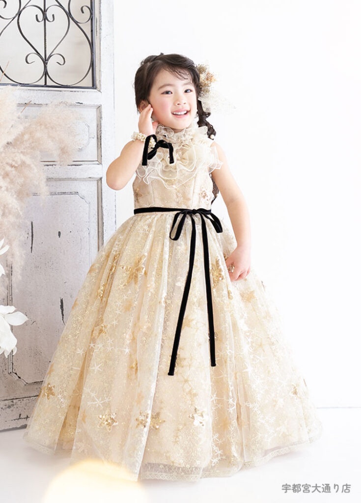 七五三３歳：ゴールドに黒いベルベットリボンがポイントのドレスを着た3才の女の子。