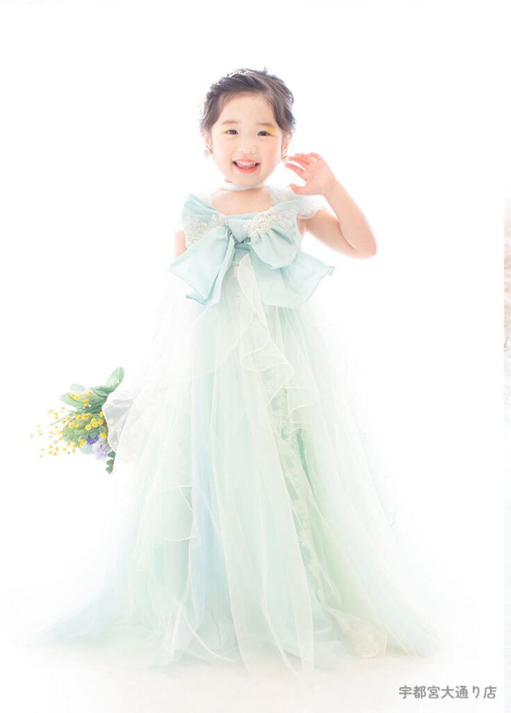 七五三３歳：エメラルドグリーンの胸のリボンがかわいいドレスを着た3才の女の子。