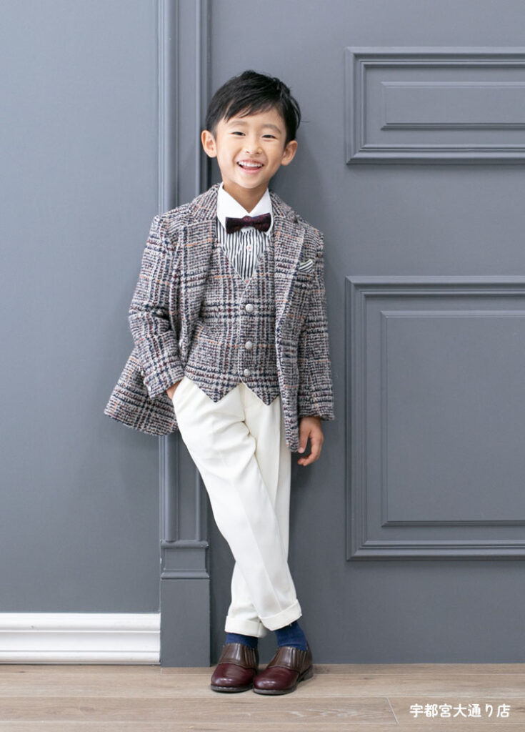 七五三５歳スーツ：グレーの織物ジャケットに真っ白いパンツを合わせた5才の男の子。