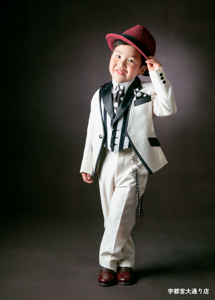 七五三５歳スーツ：黒のアクセントが素敵なホワイトスーツにストライプ柄のベストを着た5才の男の子。
