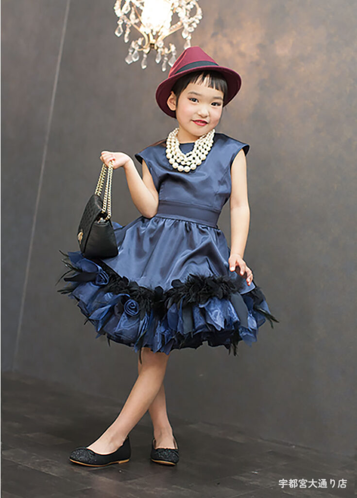 七五三７歳ドレス：ネイビーのショート丈のドレスにパールネックレスを合わせた7才の女の子。