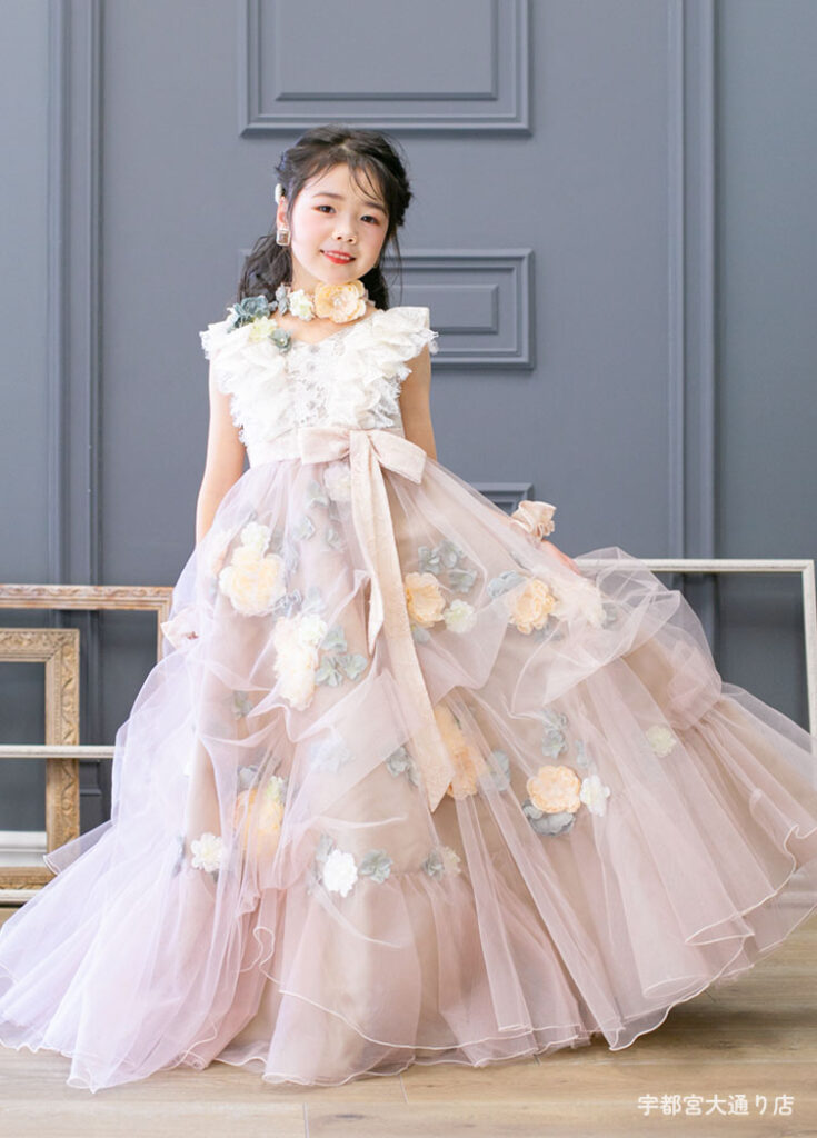 七五三７歳ドレス：くすみピンクの花がたくさん付いたドレスを着た7才の女の子。