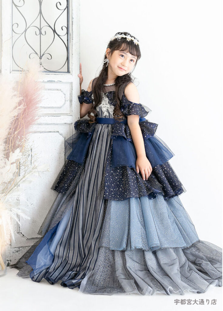七五三７歳ドレス：ネイビーのだんだんフリルのドレスを着た7才の女の子。