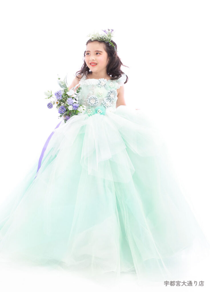 七五三７歳ドレス：エメラルドの花がたくさん飾られたドレスを着た７才の女の子。