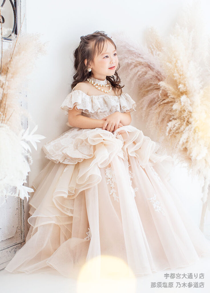 七五三３歳：くすみピンクのオフショルダードレスを着た3才の女の子。