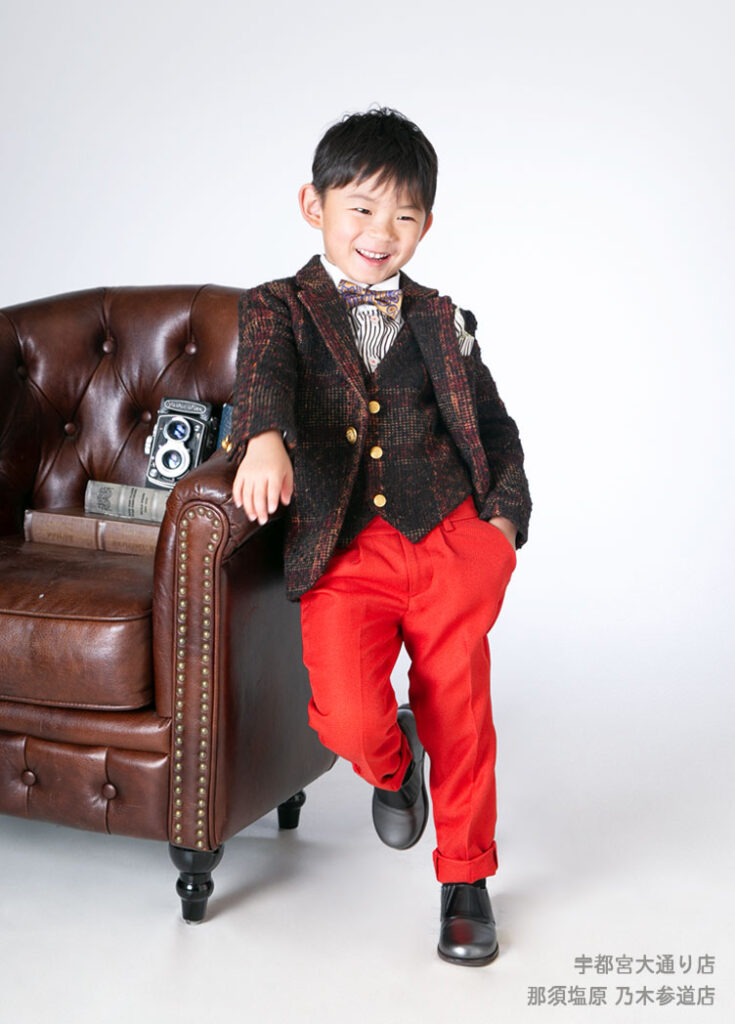 七五三５歳スーツ：ブラウンのジャケットに真っ赤なパンツを合わせたスーツを着た5才の男の子。
