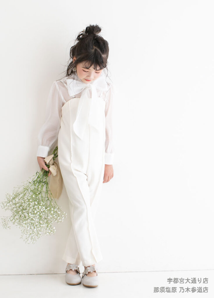 七五三７歳ドレス：真っ白いセットアップのスーツを着た7才の女の子。