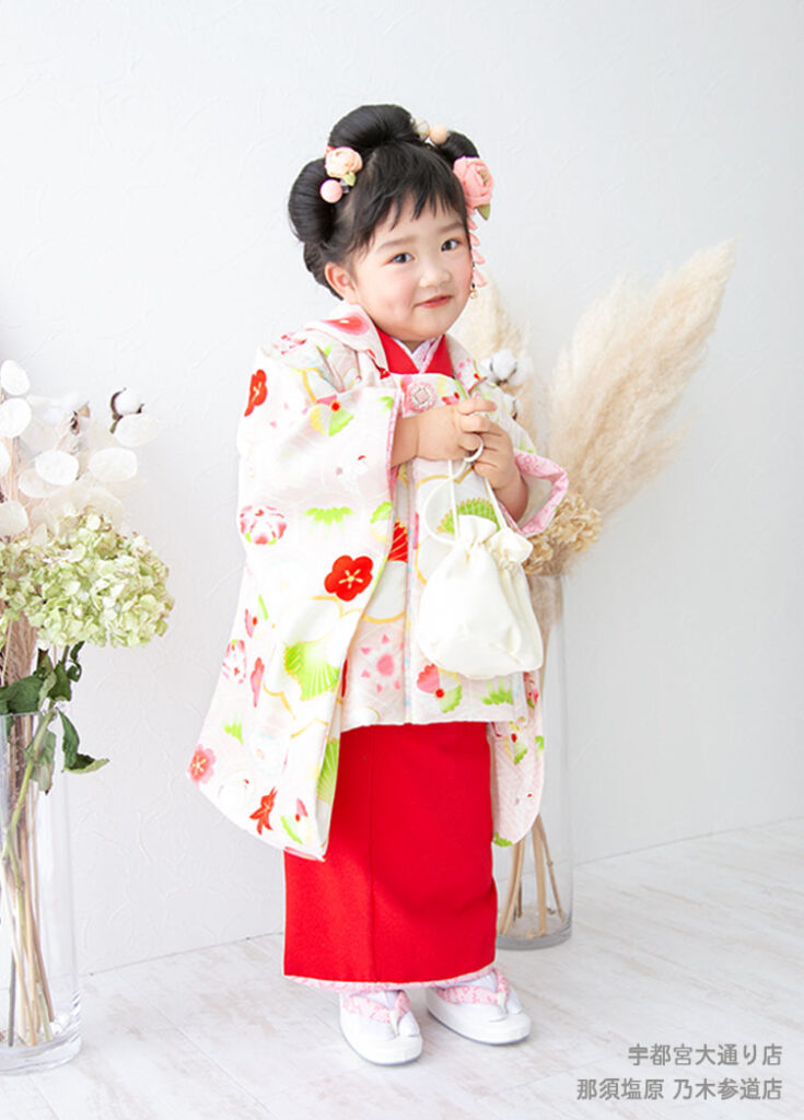 七五三３歳：白い梅の花模様の被布コート着物を着た3才の女の子。