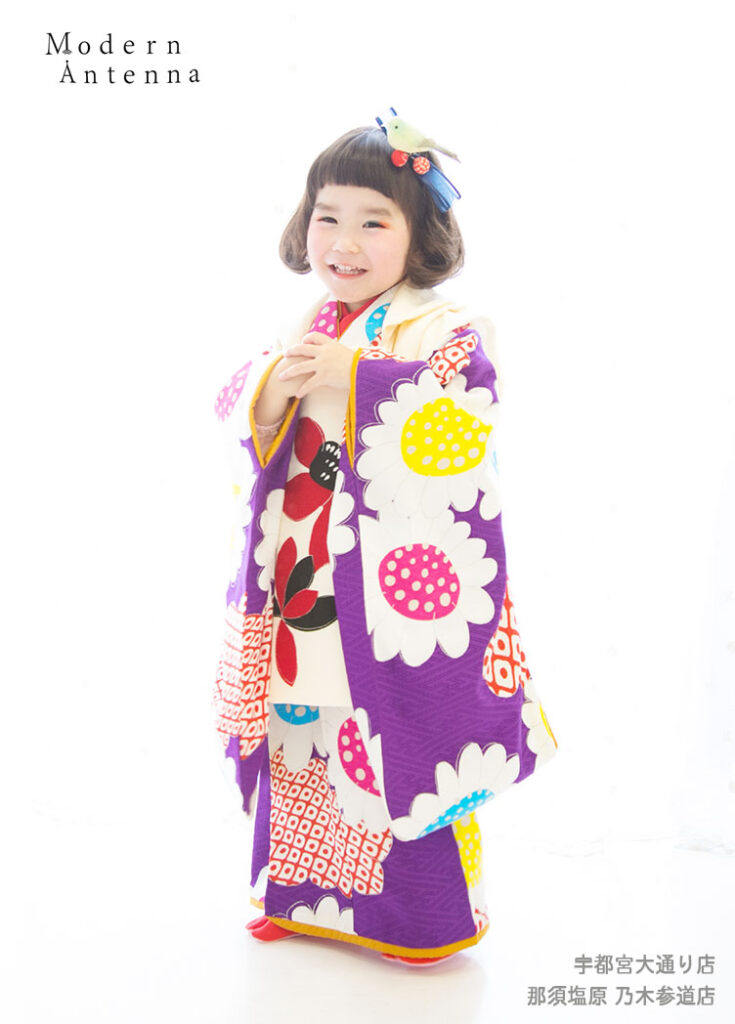 七五三３歳：レトロモダンでポップな色合いの個性的な着物を着た３才の女の子。