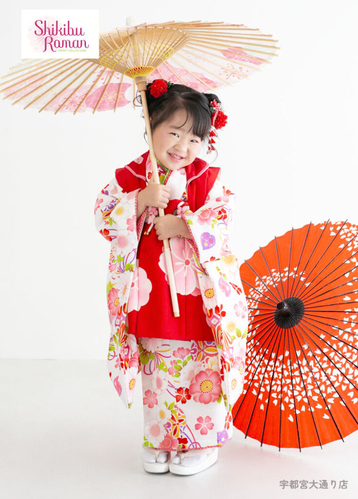 七五三３歳：白い着物に赤い被布の着物を着た3才の女の子。