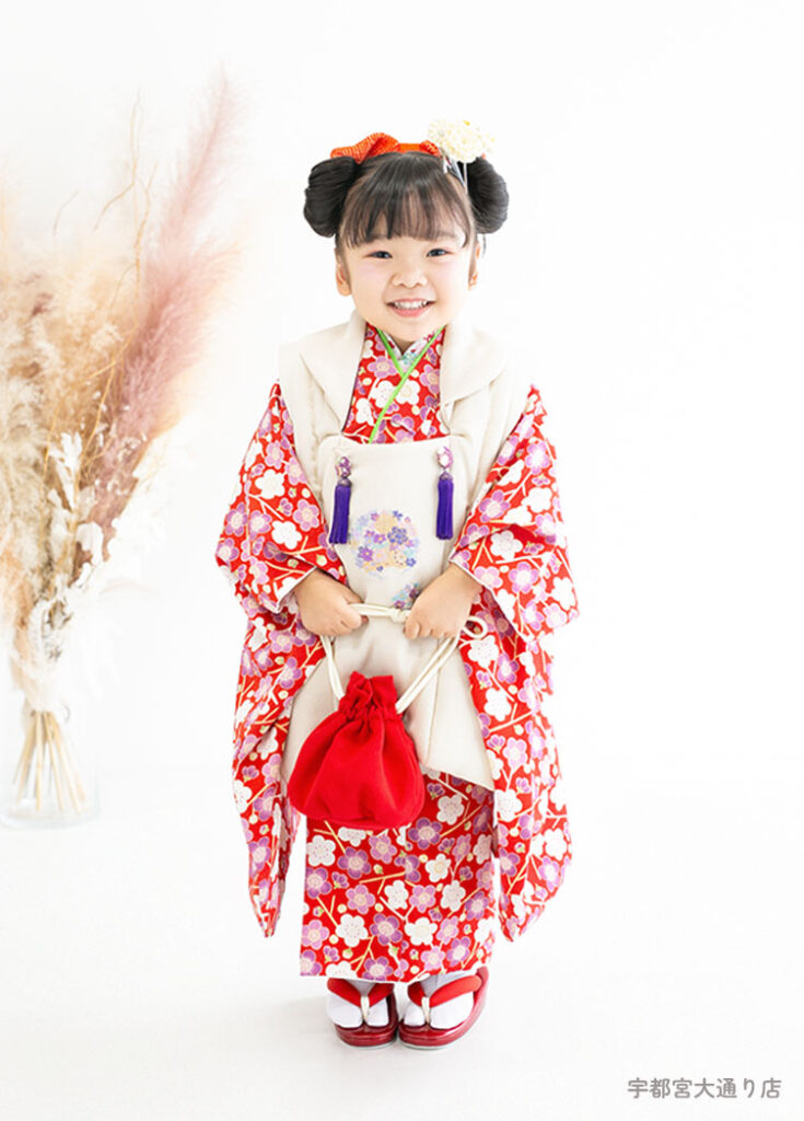 七五三３歳：赤い小花柄に白い被布の着物を着た3才の女の子。