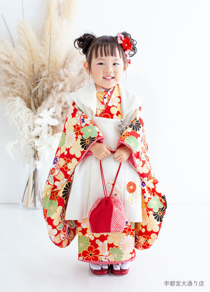 七五三３歳：赤い華やかな花柄の着物を着た3才の女の子。