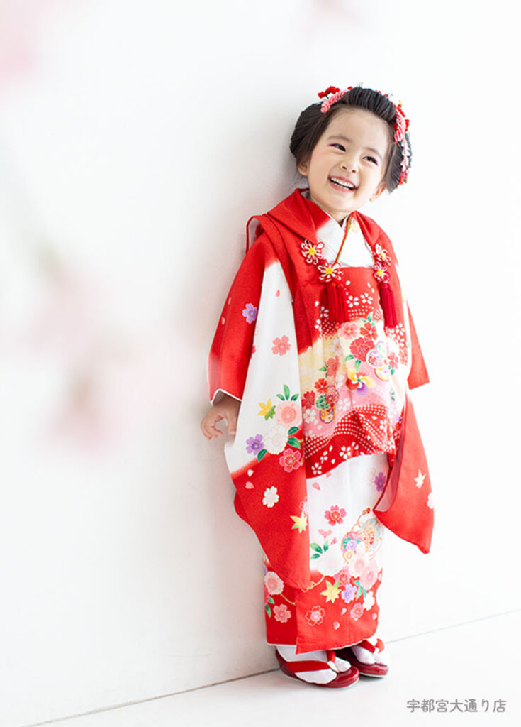 七五三３歳：赤と白がおめでたい古典的な着物を着た3才の女の子。