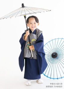七五三３歳：濃いブルーにシルバーの被布を合わせた着物を着た3才の男の子。