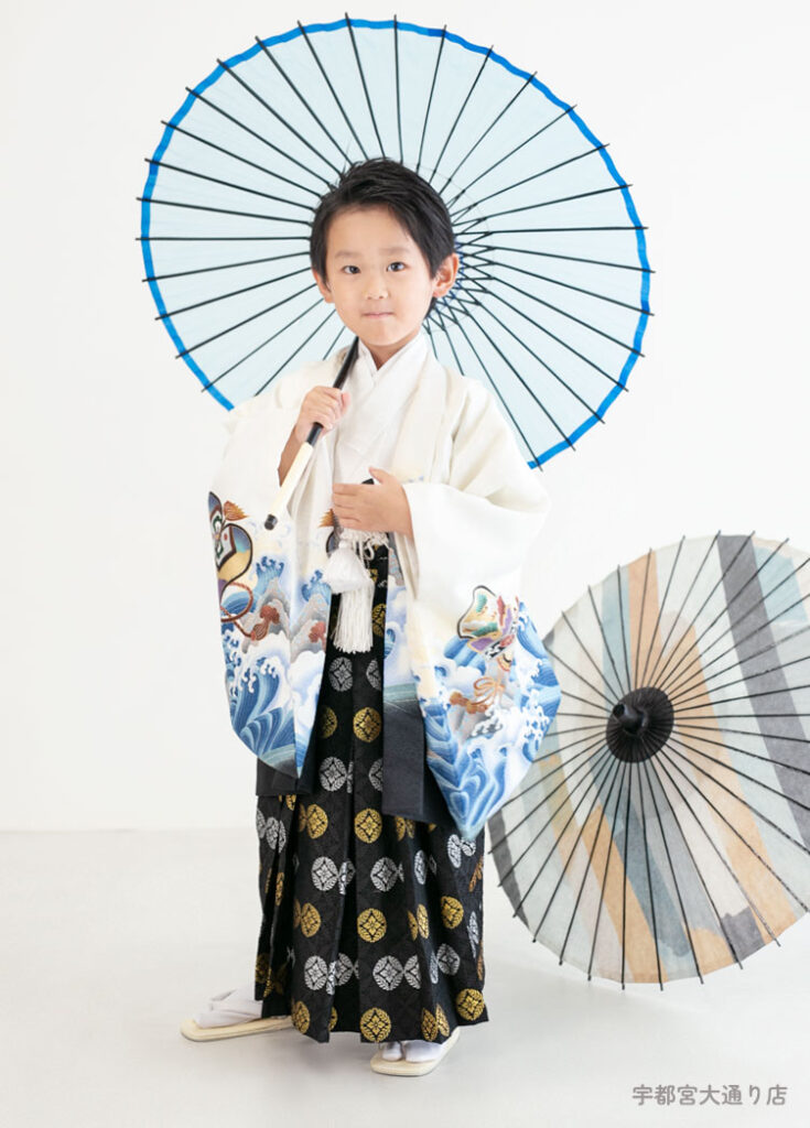 七五三５歳：白い古典柄の着物を着て和傘をさした5才の男の子。
