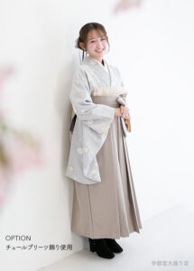 卒業袴：くすみブルーとベージュの組み合わせにチュールを合わせたおしゃれな卒業袴コーディネートの女性。