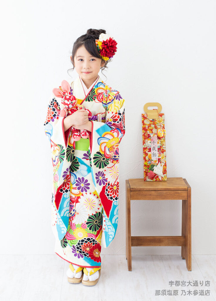 七五三７歳着物：白にカラフルな花模様の着物を着た７才の女の子。