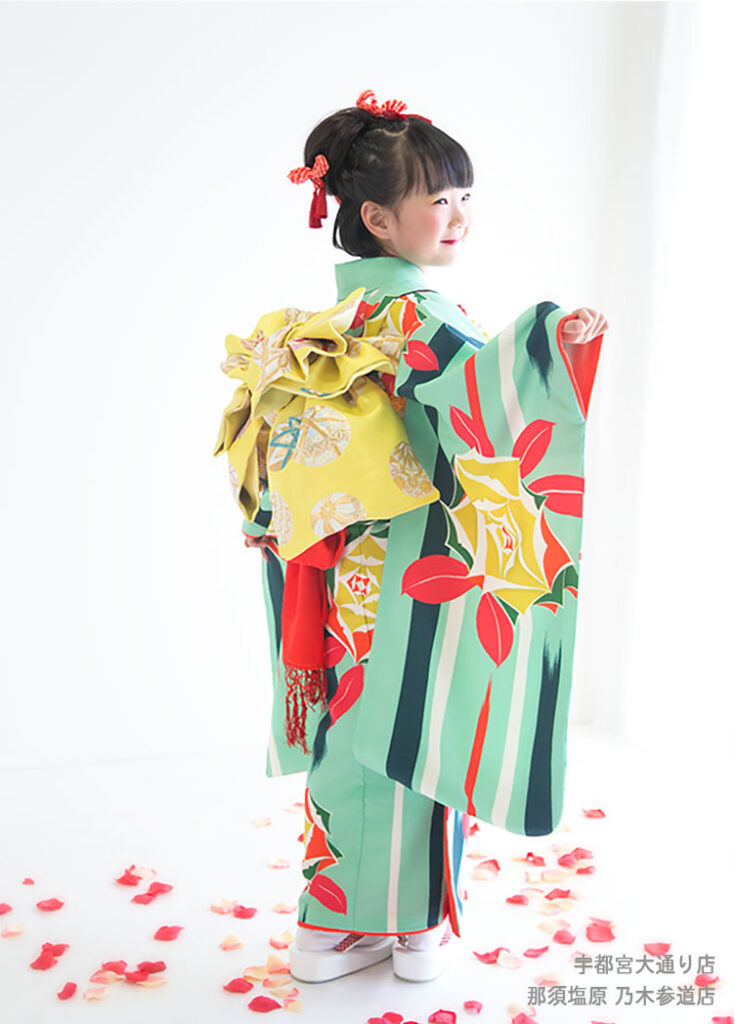 七五三７歳：エメラルドに黄色いバラ模様の着物を着た7才の女の子。