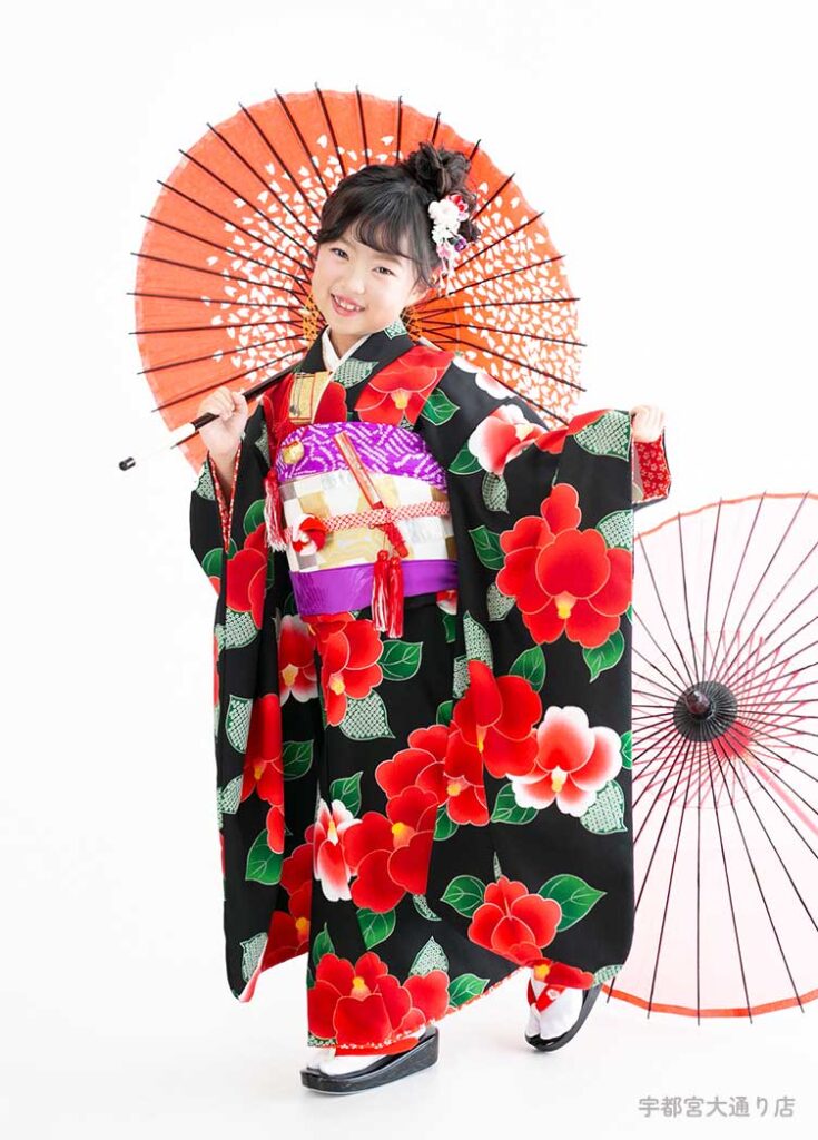 七五三７歳着物：黒に真っ赤な椿が咲き乱れる着物を着た７才の女の子。