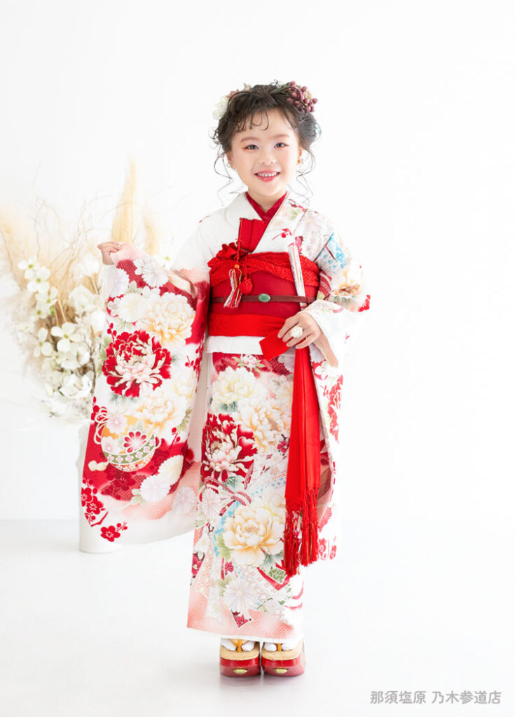 七五三７歳着物：白に赤いシャクナゲが描かれた着物を着た７才の女の子。