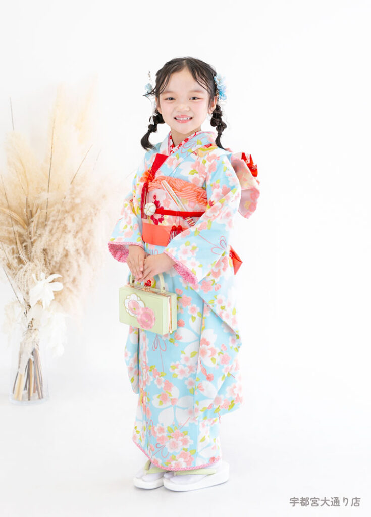 七五三７歳着物：水色の桜柄の着物を着た７才の女の子。