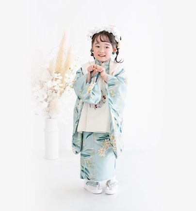 七五三３歳：水色のシュガーケイデザインのオリーブ柄の着物を着た３才の女の子。