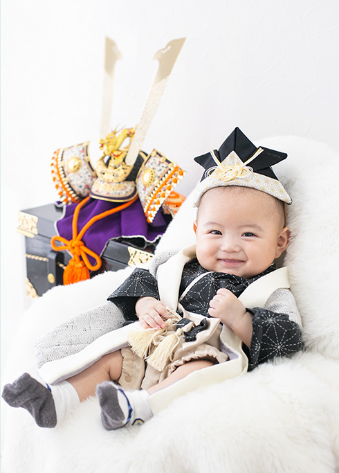 端午の節句：兜飾りとにっこり笑う男の子の赤ちゃん。