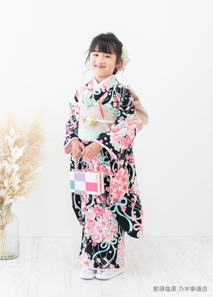 七五三７歳着物：黒とピンクの着物を着た７才の女の子。