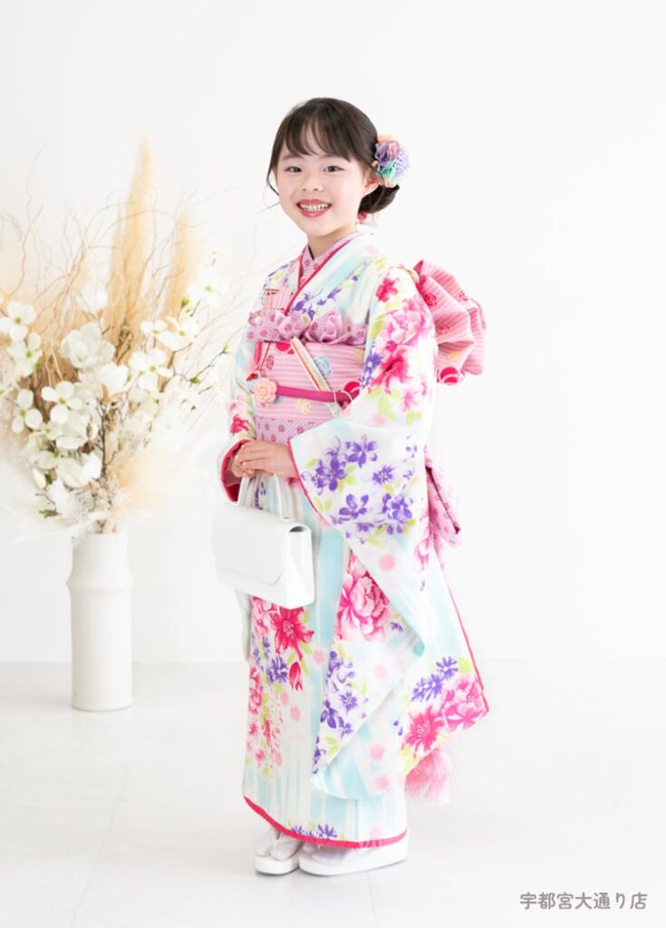 七五三７歳着物：水色とピンクの涼やかな着物を着た７才の女の子。