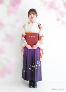 白い古典柄の着物に、刺しゅう入りの紫の袴を合わせたさわやかで上品な卒業袴コーディネート。
