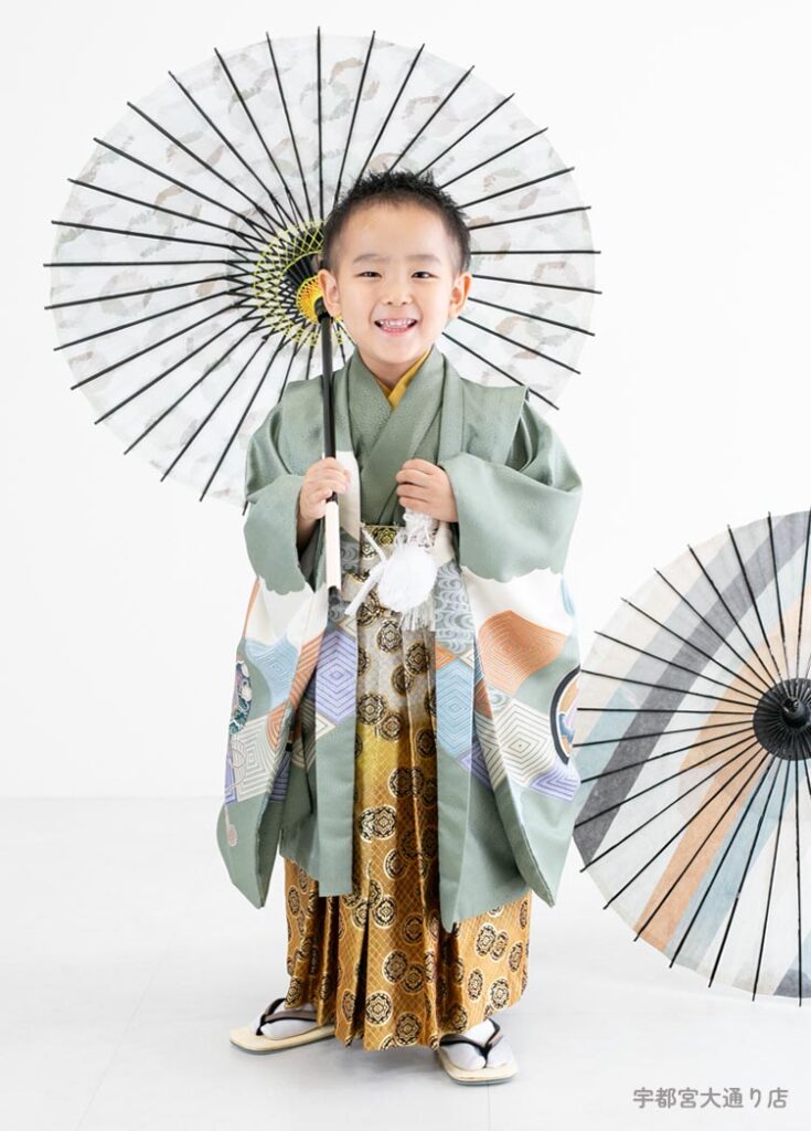 七五三５歳：くすみグリーンの古典的な柄の着物を着た5才の男の子。